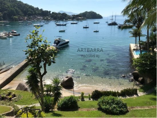 Lancha e veleiros ancorados na baía vista do jardim da propriedade