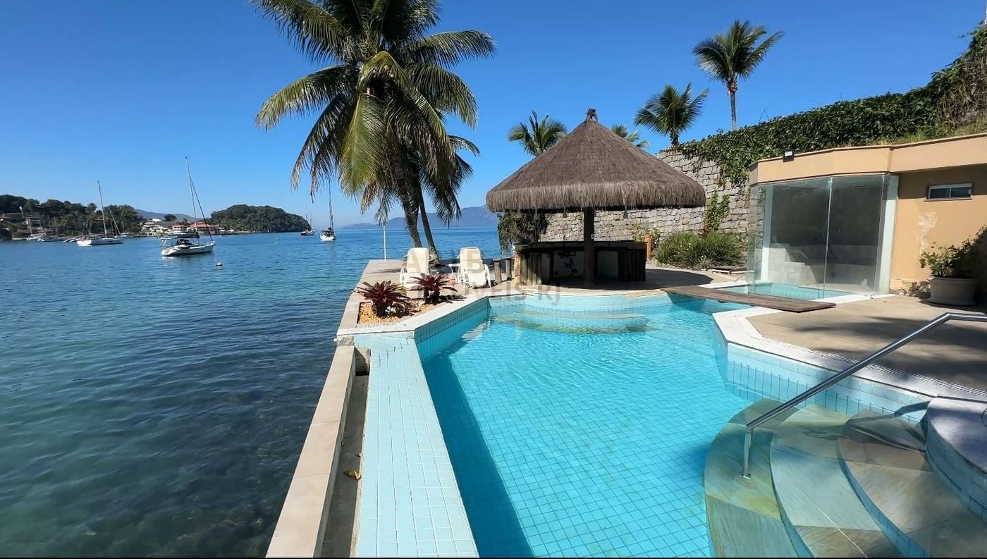 Piscina de borda infinita com sauna de vidro e vista para o mar