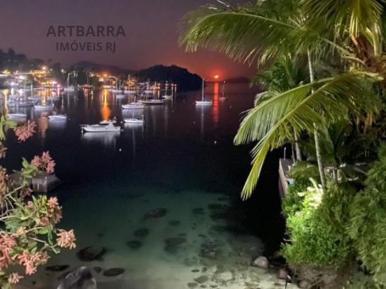Lua nascente sobre a baía iluminando a praia à noite