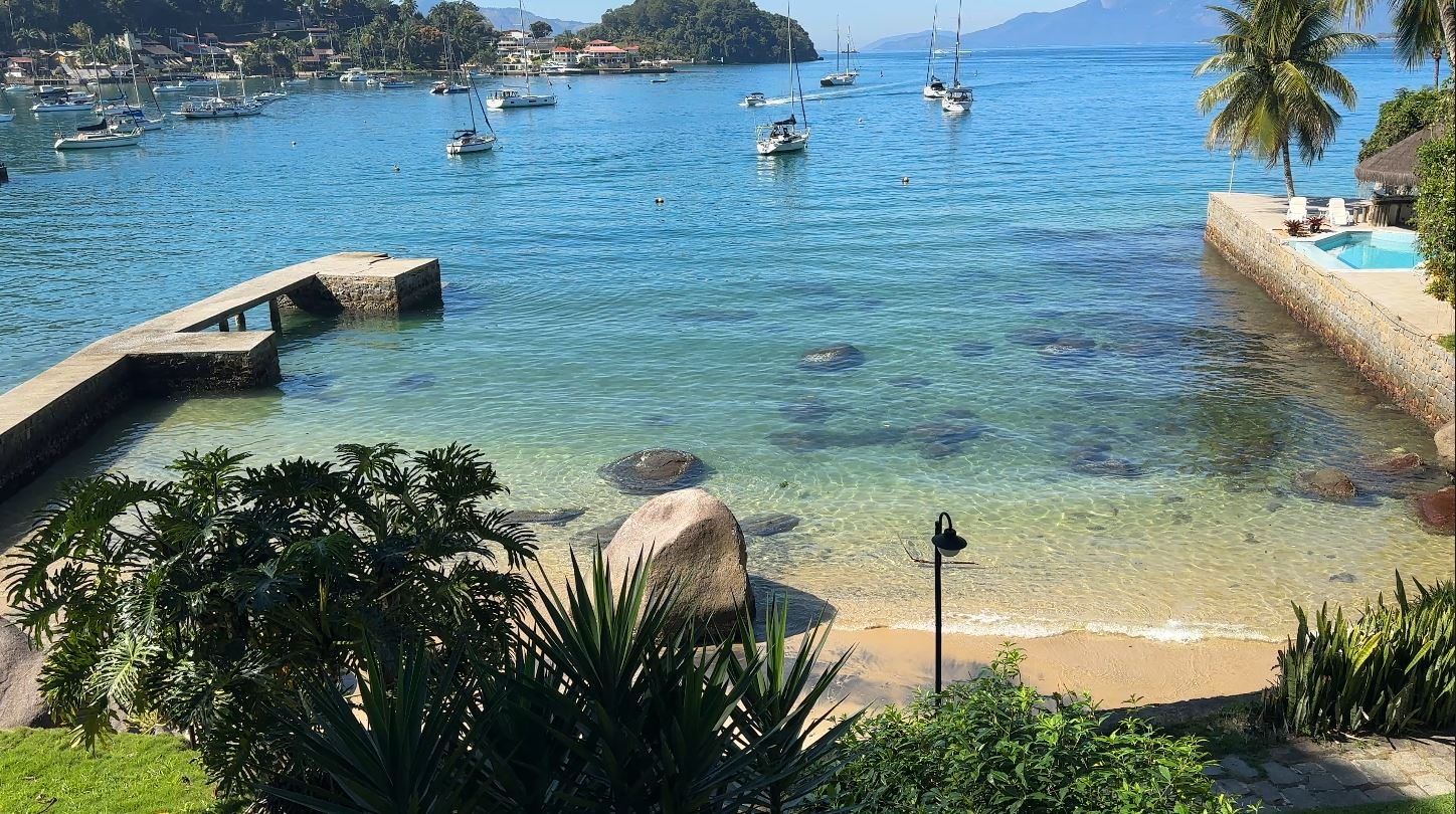 Vista da baía de Angra dos Reis a partir da propriedade, com veleiros ancorados e a Ilha Grande ao fundo